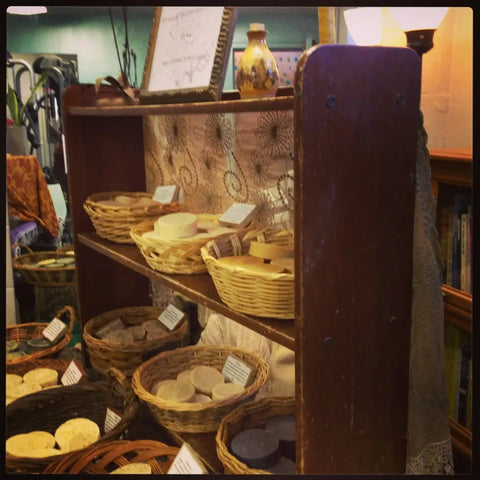 Wooden shelving unit with wicker baskets filled with soaps from Luna Herb Co. & The Smelly Gypsy.