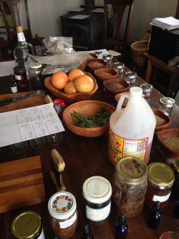 Table filled with food, jars, and supplies; article on herbal remedies by Luna Herb Co. & Smelly Gypsy.