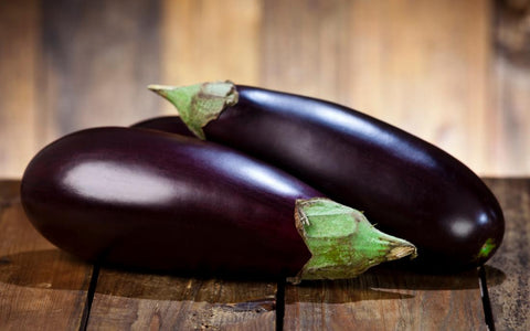 two-eggplants-on-a-wooden-table