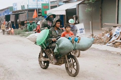 Motorcycle overloaded with passengers and large bags in rural Diên Khánh District, Vietnam.