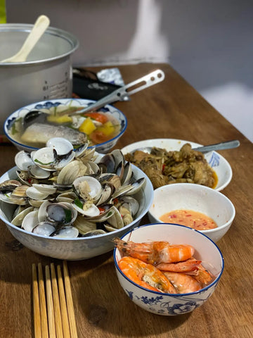 Seafood feast with clams and shrimp on a wooden table in Diên Khánh, Vietnam.